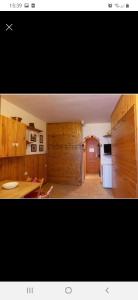 uma cozinha com armários de madeira e um frigorífico branco em Residence PARADISO em Roccaraso