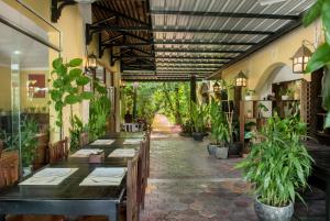 un restaurante con mesas y macetas en un pasillo en Marirath Boutique Hotel, en Siem Reap