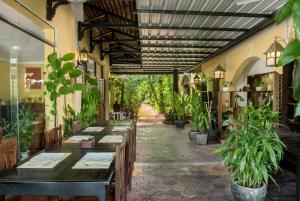 a restaurant with tables and potted plants in a hallway at Marirath Boutique Hotel in Siem Reap