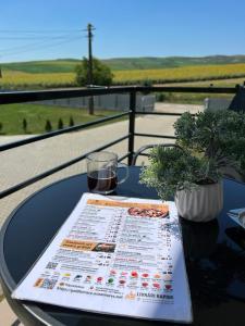 una mesa con menú y una copa de vino en La Luna Imobiliare, en Ocna-Mureşului