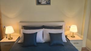 a bedroom with a bed with blue and white pillows at TRIDE Bakuriani - Apartment 60 in Bakuriani