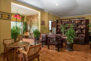 a dining room with tables and chairs and plants at Marirath Boutique Hotel in Siem Reap