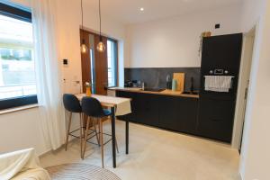a kitchen with black cabinets and a table and chairs at Goldstadt Apartments in Pforzheim