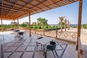 a patio with tables and chairs and a view at Azal Lagoons Resort Abu Simbel in Abu Simbel