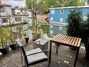 a wooden deck with a table and chairs on a balcony at NOVA Houseboat DELUXE Free Bikes in Amsterdam