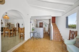 a living room and dining room with a table and chairs at Casa Jardim Oasis in Lagoa