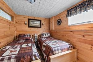Duas camas num quarto com paredes de madeira em Rustic White Mountain Log Cabin Retreat! em Rumney