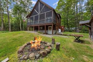 uma fogueira em frente a uma casa em Rustic White Mountain Log Cabin Retreat! em Rumney