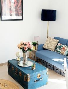 een woonkamer met een blauwe bank en een tafel met een vaas met bloemen bij Artists Apartment Montpellier-Place de la Comédie in Montpellier