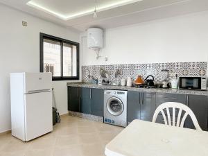 a kitchen with a washing machine and a refrigerator at La Perle Taghazout apparts 2-3px in Taghazout
