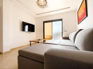 La Perle Taghazout apparts 2-3px في تغازوت: غرفة معيشة مع أريكة وتلفزيون
