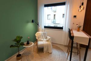 a room with a chair and a table and a window at Goldstadt Apartments in Pforzheim