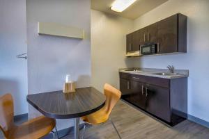 a small kitchen with a table and a sink at Motel 6-Cedar Park, TX in Cedar Park