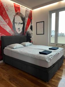 a bed in a bedroom with a large painting on the wall at Racławickie 28A in Lublin