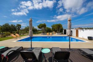 拉古阿的住宿－Casa Jardim Oasis，一个带两把露台遮阳伞的游泳池