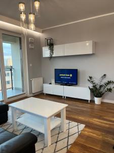 a living room with a white table and a tv at Racławickie 28A in Lublin