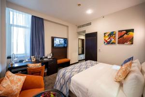 Een bed of bedden in een kamer bij Ramada Encore Doha by Wyndham