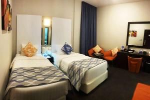 Een bed of bedden in een kamer bij Ramada Encore Doha by Wyndham