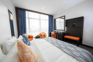 Een bed of bedden in een kamer bij Ramada Encore Doha by Wyndham
