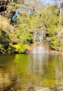 uma vista para um corpo de água com uma cascata em Paradise Lodge - Blue Mountains Wonderland em Linden