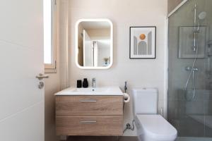 a bathroom with a sink and a toilet and a mirror at White Medano apartment. New with fast Wifi in El Médano