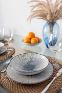 a table with plates and glasses on a table at White Medano apartment. New with fast Wifi in El Médano