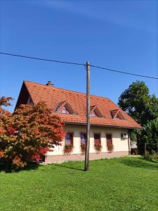 dom z czerwonym dachem i słupem w obiekcie Apartma Ob Krki w mieście Straža
