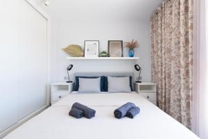 a bedroom with a bed with two blue towels on it at White Medano apartment. New with fast Wifi in El Médano