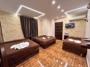 um quarto de hotel com duas camas e uma escrivaninha em Sahara Pyramids Inn em Cairo