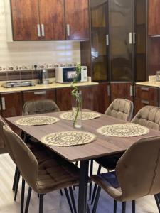 a dining room table with chairs and a kitchen at شقة فندقية عوائل ثلاث غرف نوم وغرفة معيشة ومطبخ ومدخل خاص in Riyadh Al Khabra