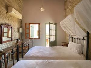 a bedroom with a large white bed and a stone wall at Eveleos Country House in Tochni