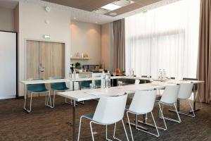 une salle de conférence avec des tables et des chaises blanches dans l'établissement Hilton Garden Inn Bordeaux Centre, à Bordeaux