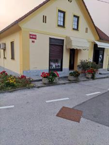 a yellow building with flowers on the side of a street at Soba Kolovrat in Straža