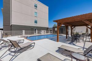 a patio with chairs and a swimming pool at Hawthorn Extended Stay by Wyndham Ardmore in Ardmore