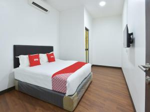 雪邦的住宿－OYO 90869 Hotel Madeena Inn，一间卧室配有红色枕头的床