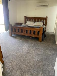 1 dormitorio con 1 cama grande de madera en una habitación en Robinson street, en Northam