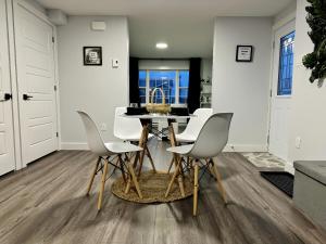 a dining room with a table and white chairs at Palm Suite St Johns - Luxury One Bedroom Apartment in St. John's
