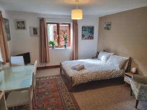 Schlafzimmer mit einem Bett, einem Tisch und einem Fenster in der Unterkunft Sunnyside in Bristol