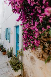 a blue door and pink flowers on a wall at Home Santa Clara in Albufeira