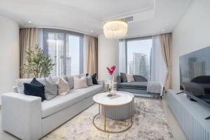 a living room with a couch and a table at Vogue Downtown - Opera Grand - Burj Khalifa & Fountain Views in Dubai