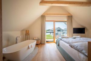 a bedroom with a large bed and a bath tub at Vila Vita Pannonia in Pamhagen