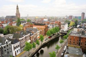 uitzicht op een stad met een rivier en gebouwen bij Business Guesthouse in Groningen