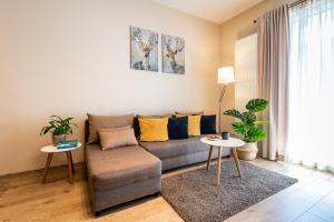 a living room with a couch and two tables at Apartamenty Tespis - Francuska Atal Park II in Katowice