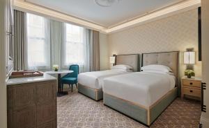 a hotel room with two beds and a table at Great Scotland Yard Hotel, part of Hyatt in London