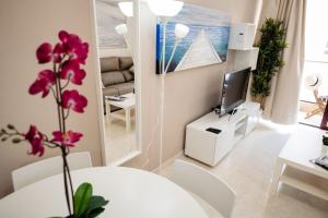 a living room with a white table and a tv at Viviendas Vacacionales Amanay in Gran Tarajal