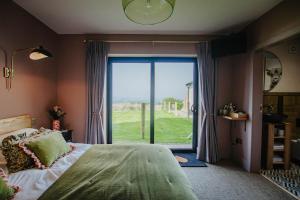 Schlafzimmer mit einem Bett und einer großen Glastür in der Unterkunft Hanley House in Tenbury