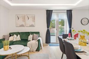 a living room with a green couch and a table at Cosy London Retreat - Sleeps 6 in London
