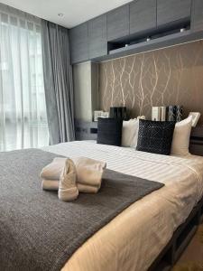 a bedroom with a large bed with two towels on it at Luxury one apartment for rent Kamala in Kathu