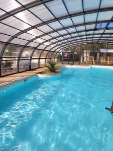 a large swimming pool with a retractable roof at Camping Riva Bella - Mobil home Les4L in Ouistreham
