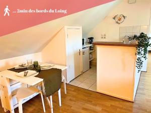 eine Küche und ein Esszimmer mit einem Tisch und einer Theke in der Unterkunft Appart cosy rénové avec AC Hypercentre Nemours in Nemours